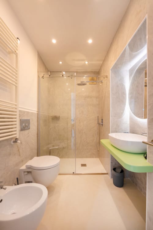 Bagno moderno nella suite Lume di Origenes Rooms a Procida con doccia walk-in, lavabo d'appoggio e scaldasalviette