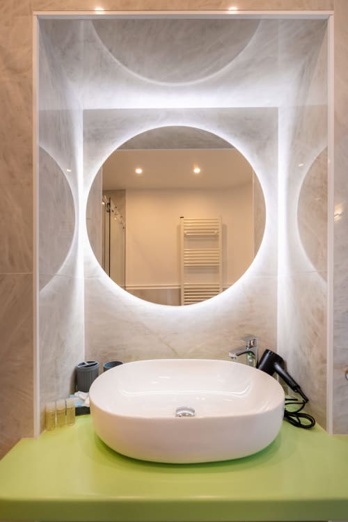Bagno moderno presso Origenes Rooms, Procida con specchio circolare illuminato e lavabo ovale bianco