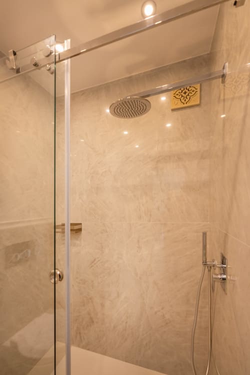 Bagno moderno con soffione a pioggia e box doccia in vetro nella suite Lume di Origenes Rooms, Procida