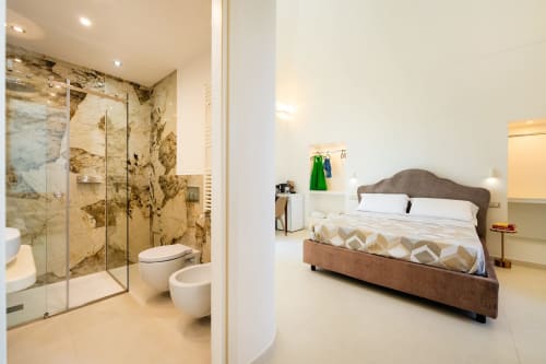 Camera moderna con bagno privato nell'appartamento Aura di Origenes Rooms, Procida, con doccia in marmo e vista mare