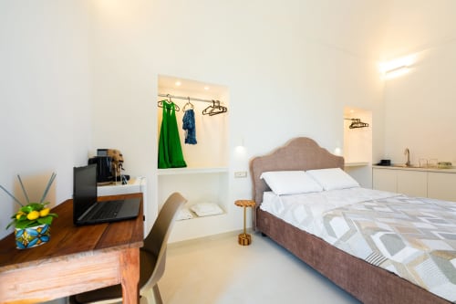 Camera luminosa in Origenes Rooms, Procida con letto matrimoniale, scrivania, angolo cottura e vista mare
