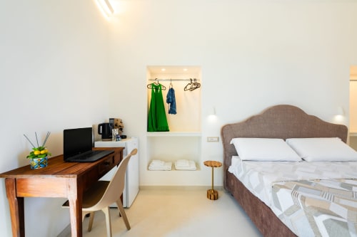 Camera moderna nell'appartamento Aura di Origenes Rooms a Procida con letto, scrivania e armadio con vista mare