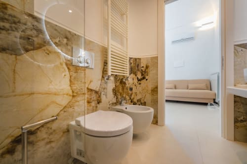 Lussuoso bagno nell'appartamento Aura di Origenes Rooms, Procida con accenti in marmo, wc e bidet moderni, doccia rain