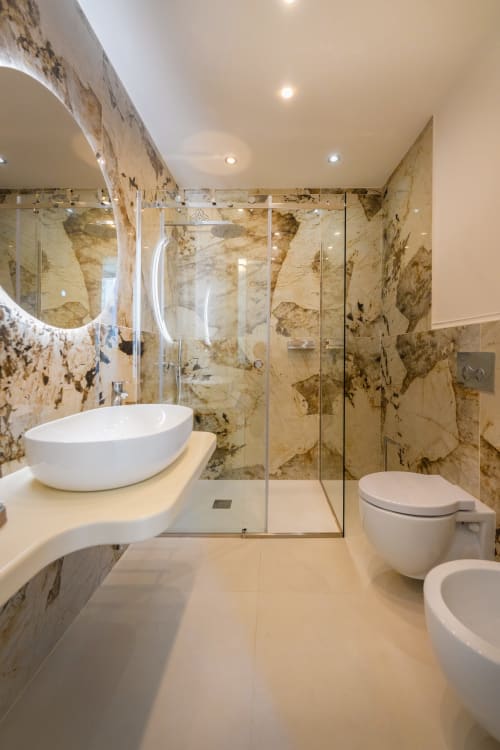 Lussuoso bagno in marmo della suite Aura presso Origenes Rooms, Procida con lavabo in ceramica, doccia in vetro e finiture moderne