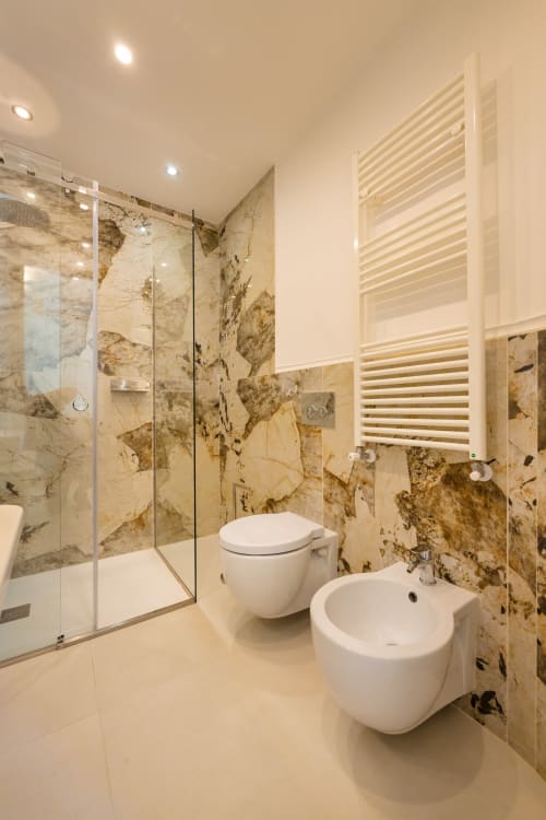 Lussuoso bagno nell'appartamento Aura di Origenes Rooms, Procida, con pareti in marmo, sanitari moderni, bidet e lavabo