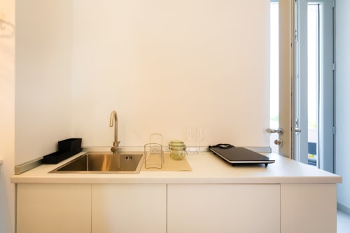 Cucina minimalista con lavello, rubinetto e dotazioni culinarie nell'appartamento Aura di Origenes Rooms, Procida
