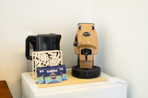 Macchina da caffè Nespresso con bollitore d'acqua e capsule Borbone nella stanza Aura di Origenes Rooms, Procida