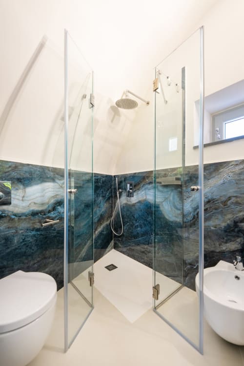 Moderno bagno con doccia aperta e piastrelle in marmo blu nell'appartamento Onda di Origenes Rooms, Procida