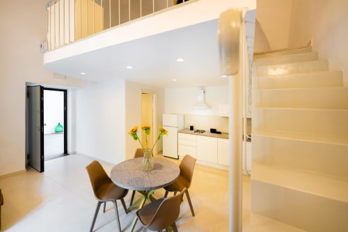Moderno appartamento open-plan a Procida con zona pranzo, cucina, scale e soppalco presso Origenes Rooms