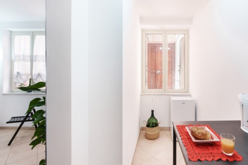 Modern kitchenette in VILLALBE room at Origenes Rooms, Procida, with tiled flooring, small dining area, and coastal view