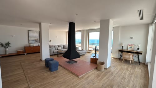 Spacious Panoramic Penthouse living area in Sesimbra with sea views, modern fireplace, and furnished balcony
