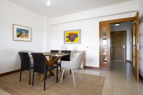 Área de refeições moderna no apartamento DANI do hotel RB Algarve, Vilamoura, com mesa de madeira e cadeiras em preto e branco