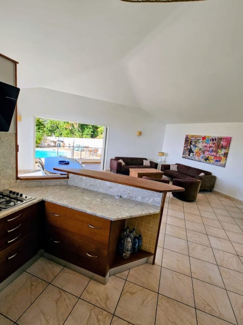 Modern open-plan kitchen and living area in Villa Eva at Corsu Di Core, Favone, with sea view access and pool visible through
