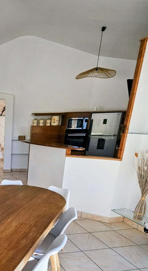 Modern kitchen in Villa Eva at Corsu Di Core with white walls, wood accents, stainless appliances, and designer pendant light