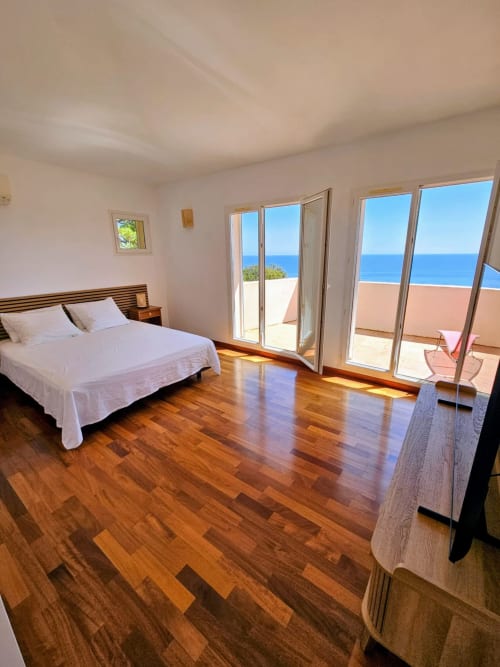 Spacious sea-view bedroom in Villa Eva at Corsu Di Core, Favone, with wooden flooring and direct terrace access