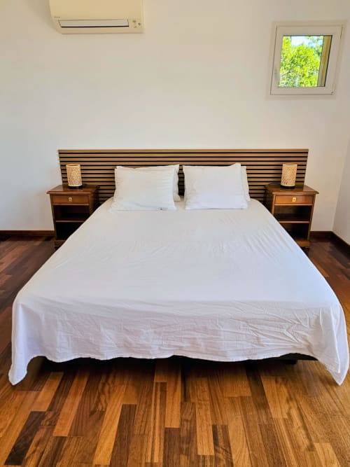Modern bedroom in Villa Eva at Corsu Di Core, Favone, with white bedding and striped headboard