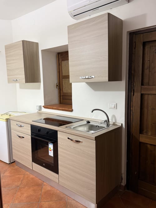 Angolo cottura moderno a Borgo Luce, Francavilla Marittima - camera al piano terra con mobili in legno chiaro, fornelli e lavello