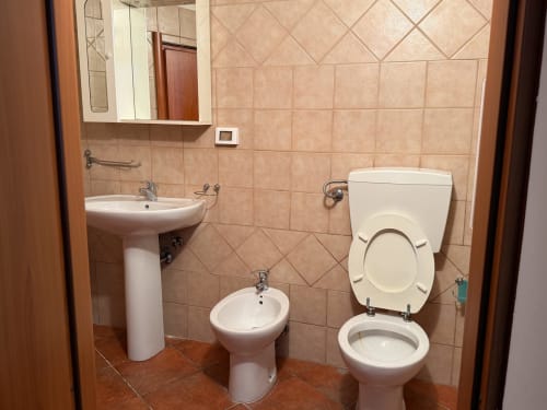 Bagno moderno al Borgo Luce B&B di Francavilla Marittima con lavabo su piedistallo, bidet, wc e pareti piastrellate