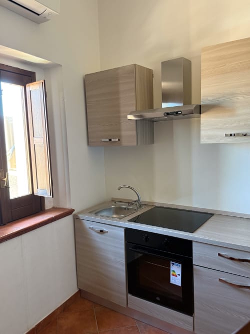 Cucina moderna nella camera Matrimoniale di Borgo Luce B&B, Francavilla Marittima con mobili in legno chiaro e acciaio inossidabile