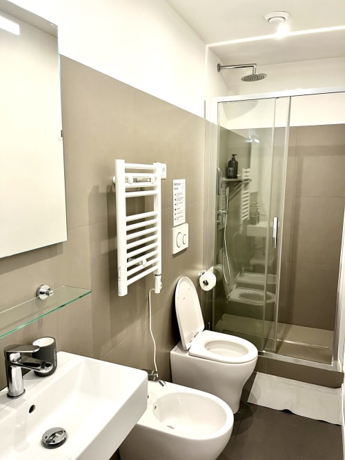Bagno moderno nella B&B di Roma con doccia in vetro, asciugamani bianchi, lavandino, wc e bidet