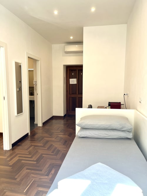 Moderna camera da letto presso Domus Giovanna Roma B&B con pavimento in legno spina di pesce, letto e vista panoramica della città