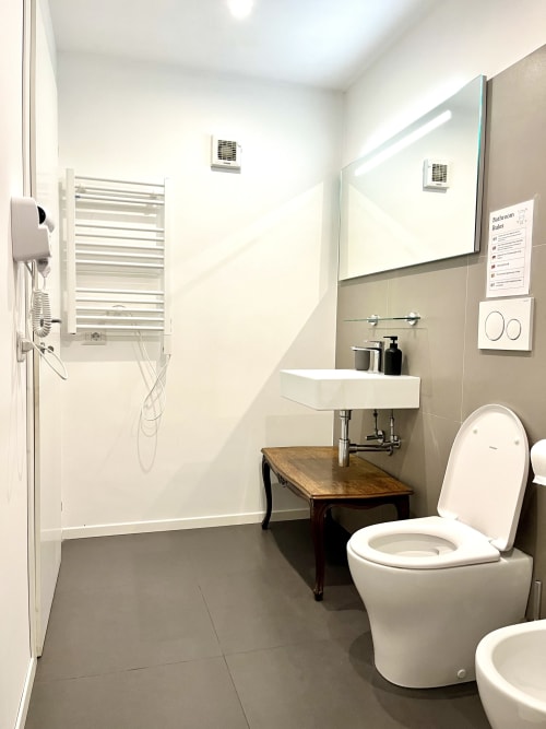 Moderno bagno della Domus Giovanna Roma B&B con toilette, lavabo, box doccia, scaldasalviette e pavimentazione in piastrelle.