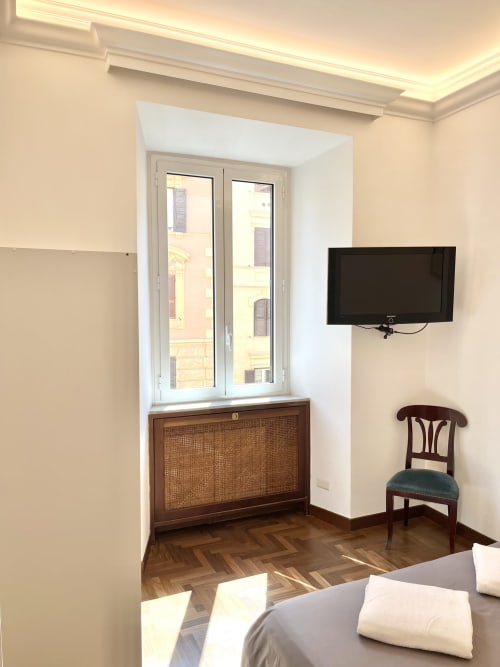Camera moderna a Domus Giovanna Roma B&B con pavimento in spina di pesce in legno, TV a parete e porte-finestre