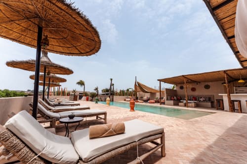 Piscine sur le toit du Riad Arkaya à Essaouira avec transats, parasols en chaume et bassin turquoise