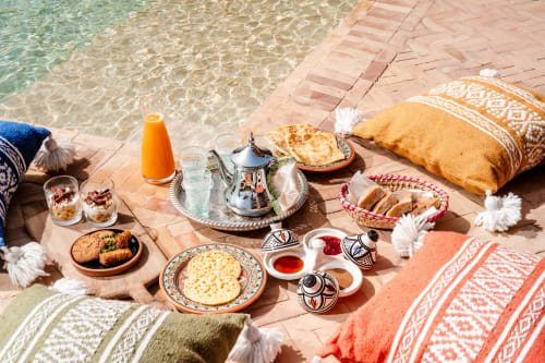 Petit-déjeuner en bord de mer au Riad Arkaya à Essaouira avec pâtisseries marocaines traditionnelles, service de thé et sièges moelleux