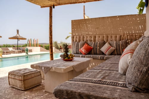 Espace lounge du Riad Arkaya à Essaouira avec sièges confortables, vue sur la piscine et architecture marocaine traditionnelle