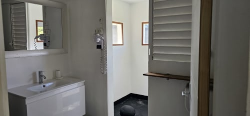 Salle de bains moderne avec lavabo, miroir et douche à la villa Les Cassias de Petit-Bourg, Guadeloupe