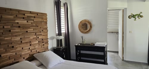 Chambre moderne à l'Habitation Villa Les Cassias à Petit-Bourg avec mur en bois, commode noire et vue sur la piscine