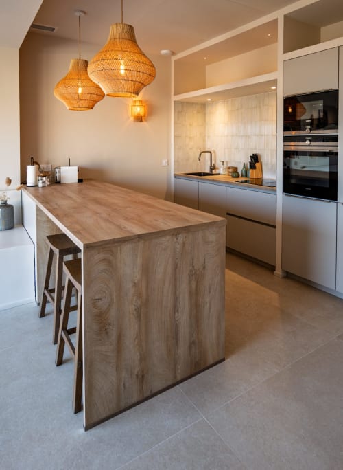 Cuisine moderne de la villa Can Jeannette à Collioure avec îlot bois, luminaires en suspension tressés et électroménagers inox