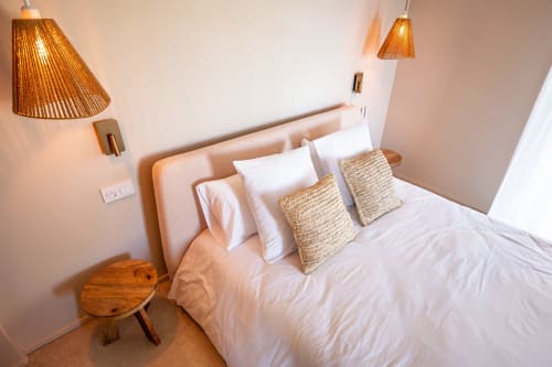Chambre moderne de la villa Can Jeannette à Collioure avec literie blanche, luminaires suspendus tressés et détails en bois