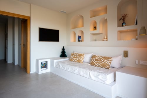 Chambre moderne de la villa Can Jeannette à Collioure avec lit intégré, oreillers dorés, TV murale et éclairage ambiant