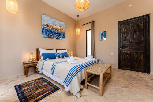 Chambre Mogador au Riad Arkaya, Essaouira : chambre lumineuse avec lit queen-size, linge de lit rayé bleu, mobilier en bois et jardin