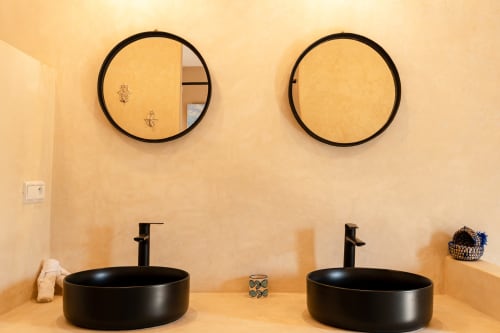 Vasques noires duales avec miroirs circulaires dans la salle de bain Chambre Mogador de Riad Arkaya, Essaouira