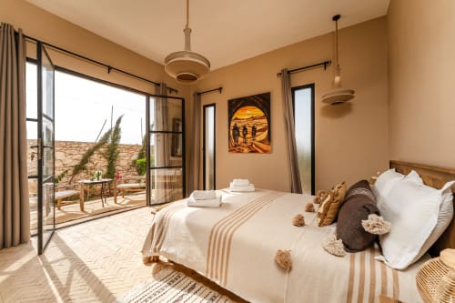 Chambre Beldi au Riad Arkaya à Essaouira avec terrasse jardin, décor épuré et mobilier d'inspiration marocaine