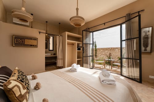 Chambre Beldi au Riad Arkaya à Essaouira avec vue jardin, luminaires suspendus tissés et accès terrasse
