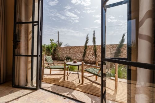 Terrasse privée du Riad Arkaya à Essaouira avec vue sur le jardin, chaises longues et murs en pierre