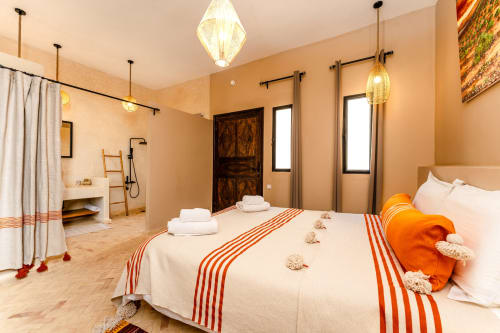 Chambre accessible au Riad Arkaya à Essaouira avec lit queen, salle de bain privée, éclairage ambiant chaleureux et design moderne