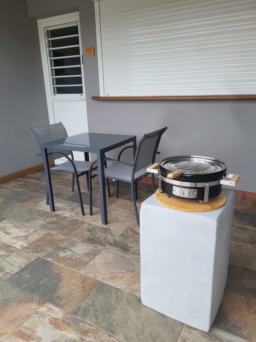 Terrasse extérieure de la Villa Maloem avec table de salle à manger, chaises et barbecue intégré à l'appartement Sainte-Anne