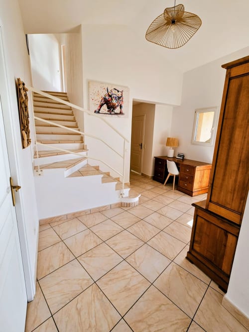 Modern villa entryway with wooden staircase, tiled floor, and elegant furnishings at Corsu Di Core, Favone