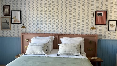 Chambre double de l'Hôtel Saint Enogat à Dinard avec lits jumeaux, coussins rayés et papier peint à motifs ondulés