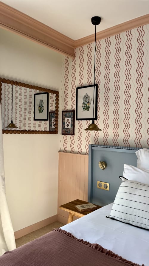 Chambre d'hôtel moderne à l'Hôtel Saint Enogat avec papier peint à motifs ondulés, gravures botaniques encadrées, éclairage suspendu