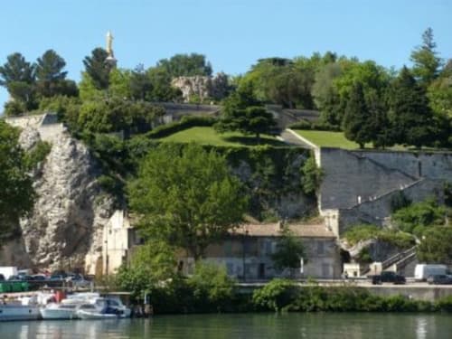 Hôtel Oriflamme & Travertin avec fortifications en pierre surplombant le fleuve et bateaux amarrés, Avignon France