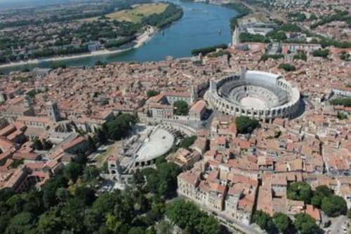 Vue aérienne de l'arène de Nîmes et de la ville aux toits rouges avec le Rhône, localisation hôtel Oriflamme & Travertin