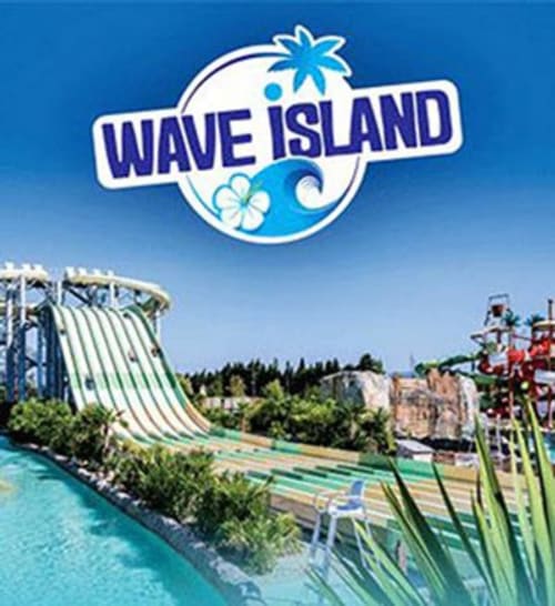 Parc aquatique Wave Island avec bassin à vagues, toboggans et paysage verdoyant en France