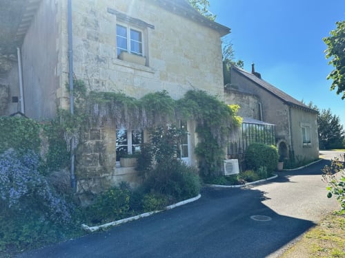 Maison Melrose, chaumière en pierre à Vouvray avec murs couverts de lierre et glycine en fleurs