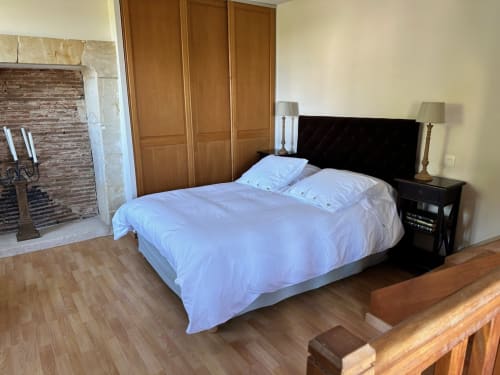 Chambre spacieuse à la Maison Melrose à Vouvray avec lit queen-size, cheminée et armoire en bois